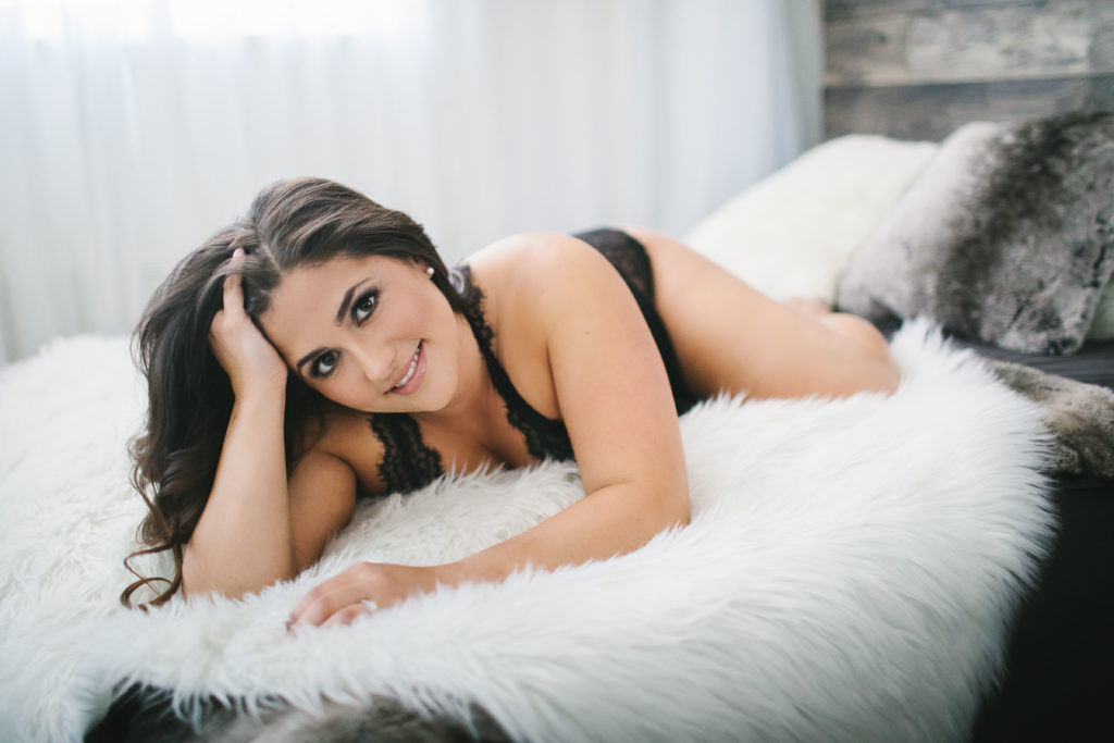 Boudoir Photography - Woman in black lingerie on white bed