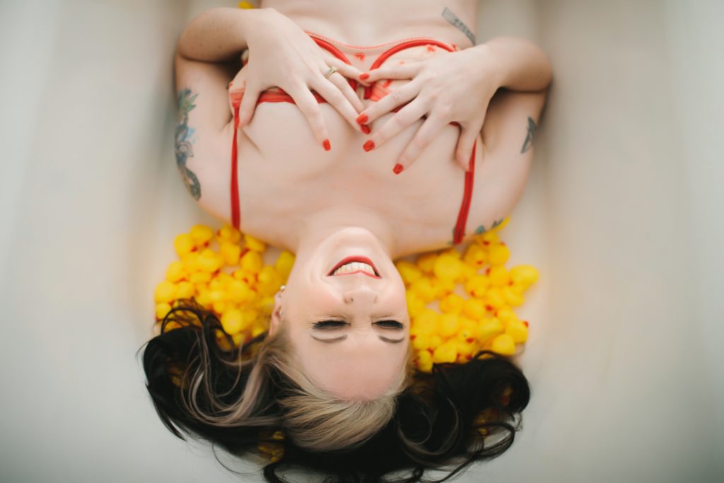 brunette in peach lingerie in bathtub with rubber ducks; reinvented boudoir photography by Lindsay Hite,  how to prepare for a boudoir session