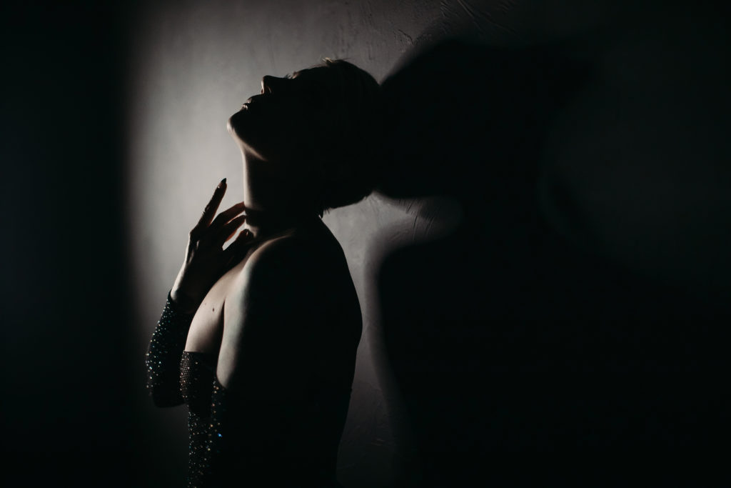 boudoir photography, capturing the light in a dark scene, women's empowerment photography by Lindsay Hite