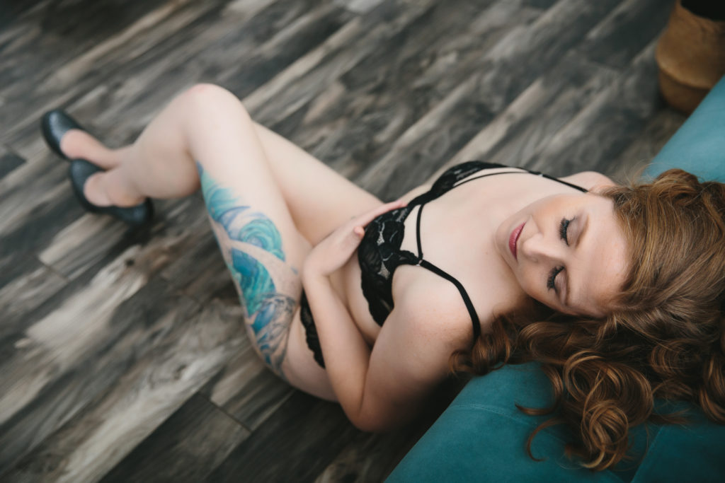 brunette in black lingerie on teal sofa; women's empowerment photography by Lindsay Hite