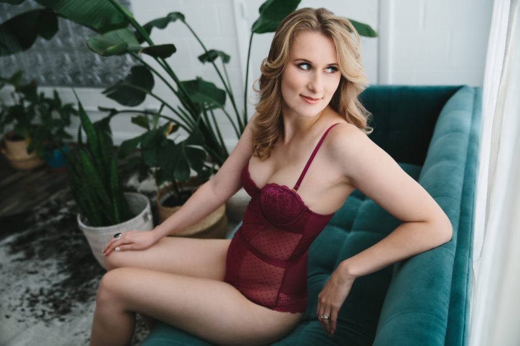 blonde in rose colored lingerie, on teal sofa; boudoir photography by Lindsay Hite