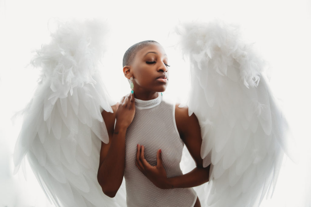 Woman in white with white background and white angel wings