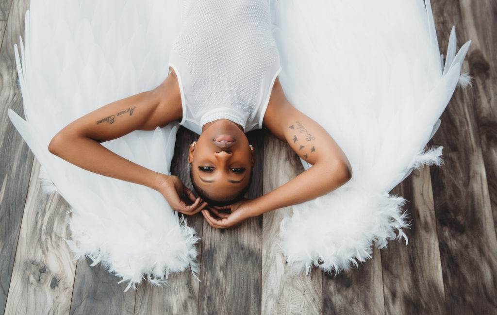 Woman in angel wings on wooden floor; Creativity fosters creativity; boson boudoir by Lindsay Hite