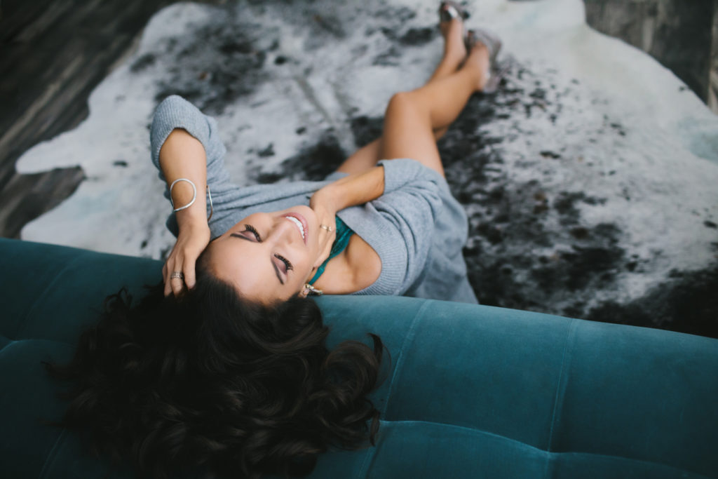 Woman in oversized sweater sitting on the ground, boudoir photography by Lindsay Hite