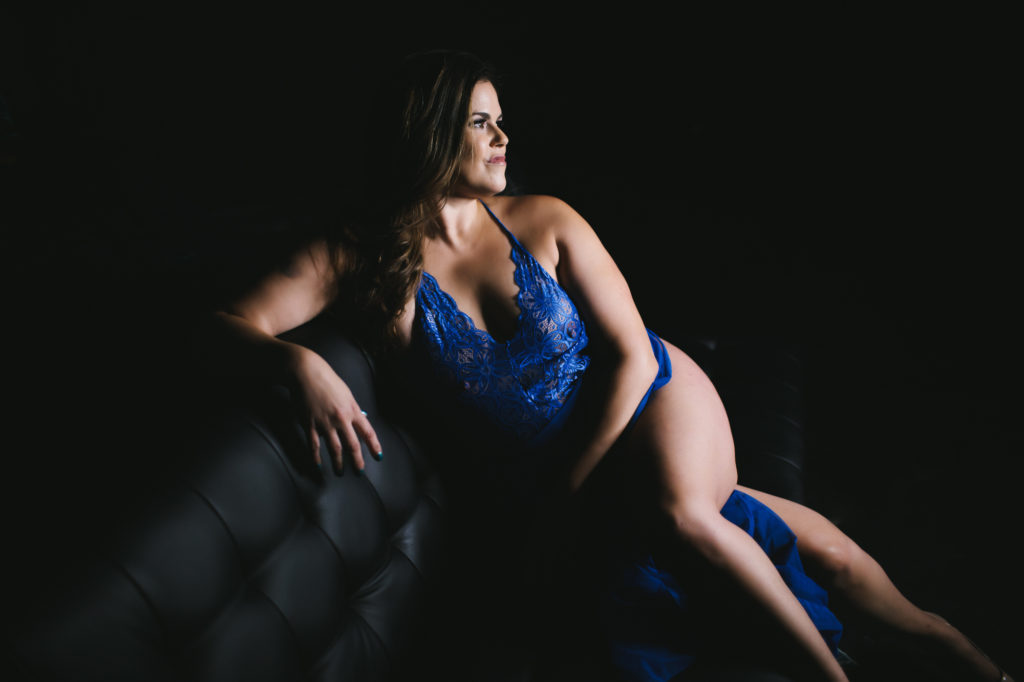 woman in blue lingerie on a black leather couch; photography by Lindsay Hite