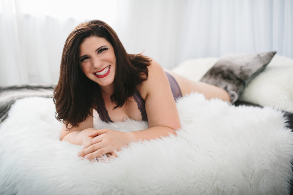 Woman in lingerie on fur lined bed, boudoir photography by Lindsay Hite