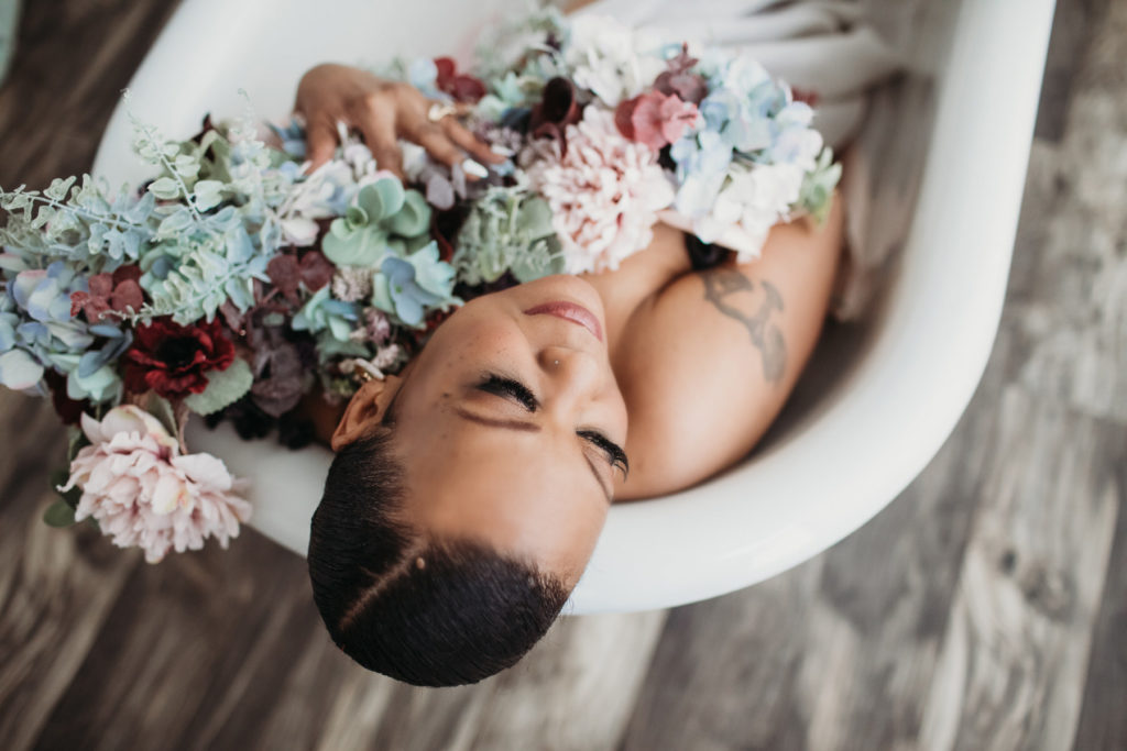 Woman in bathtub holding flowers; boudoir photography by Lindsay Hite - How to overcome imposter syndrome-- self-care
