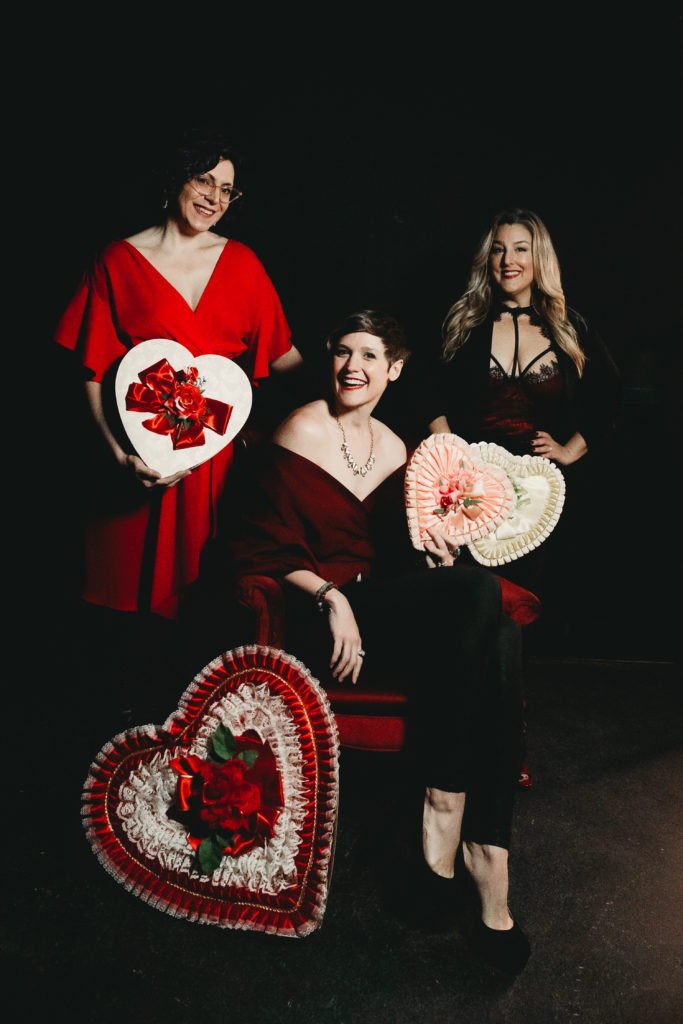 Boston-Area Luxury Photography Studio; The Team in red outfits, black background, and vintage Valentine's Day boxes