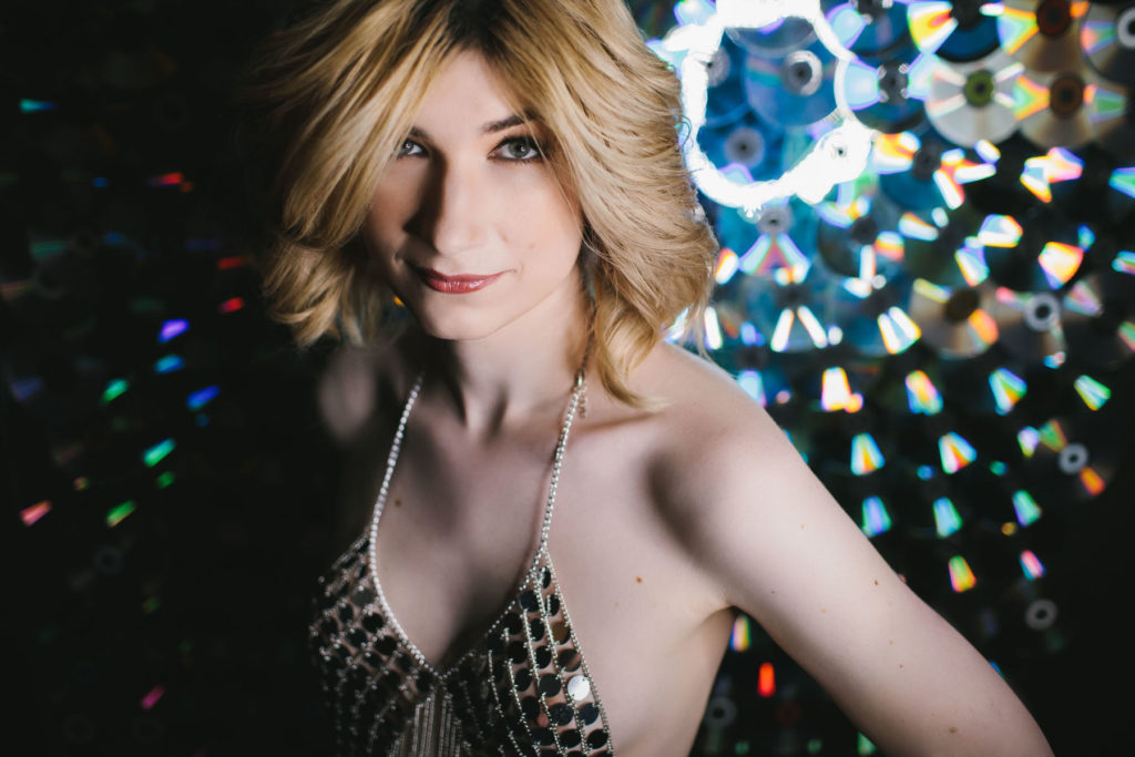 Woman in sparkly top in front of CD Wall, boudoir photography by Lindsay Hite