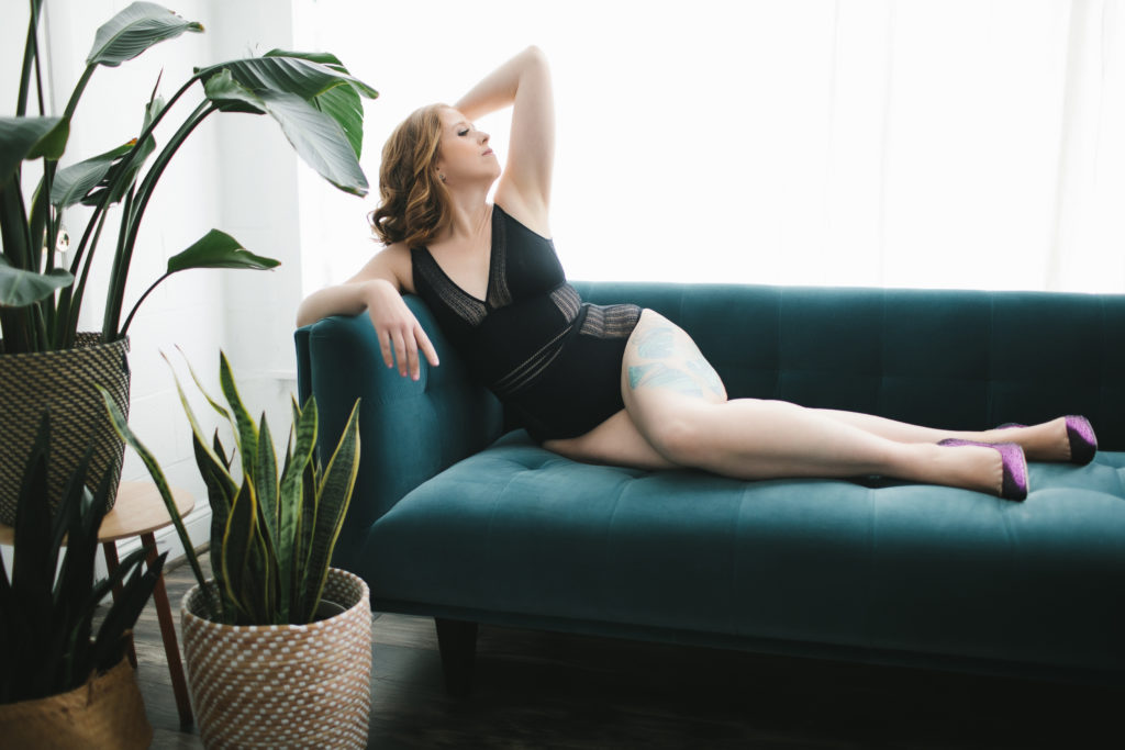 woman in black lingerie and purple heels on teal sofa; accept your body now, boudoir photography by Lindsay Hite