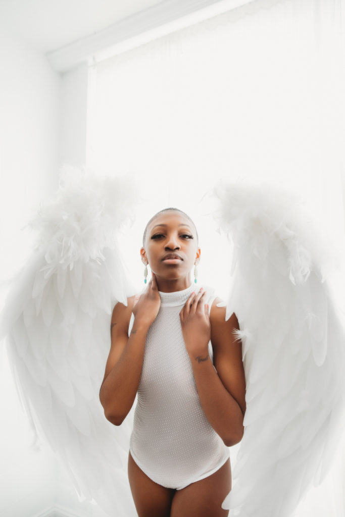 African American Woman in white leotard and angel wings, bonus scene by Lindsay HIte