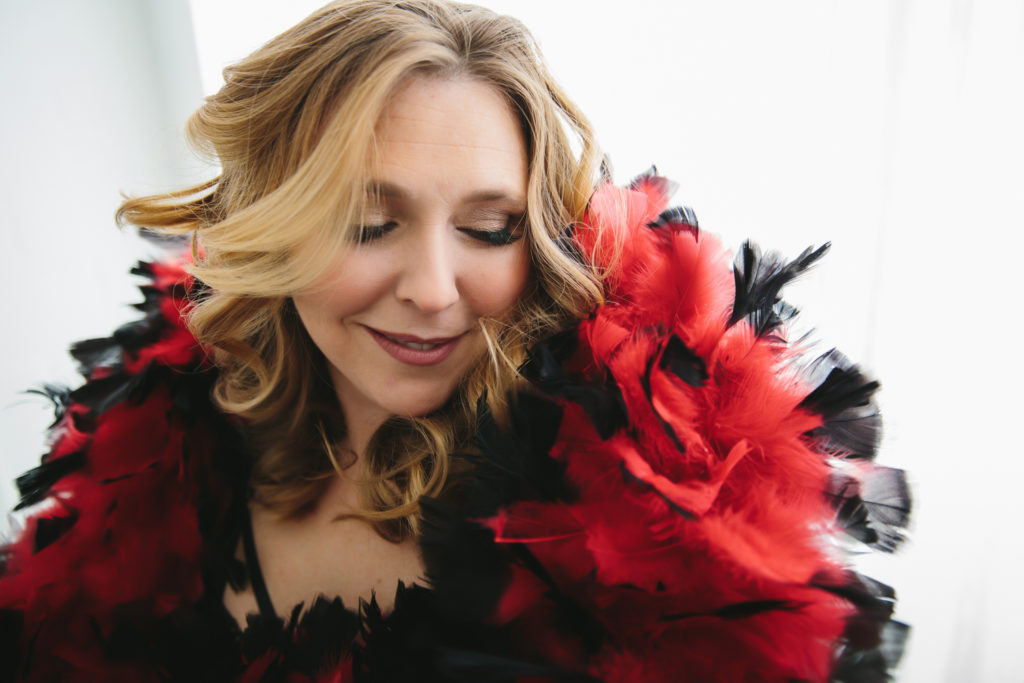Woman with red and black boa; boudoir photography by Lindsay Hite
