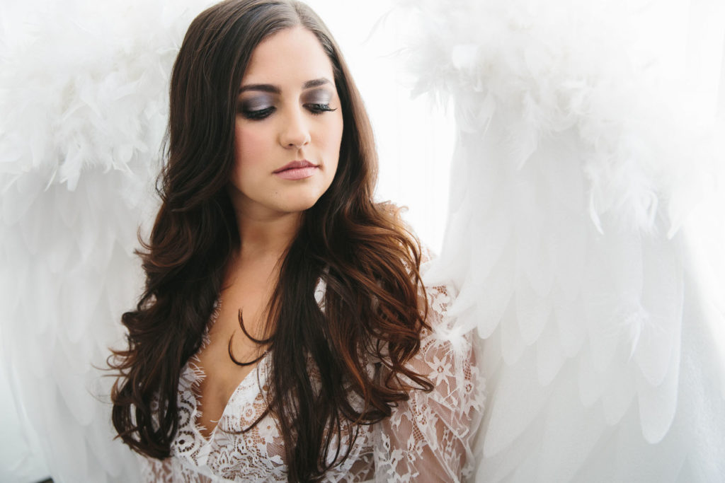 Woman in bridal lingerie and white angel wings, by Lindsay Hite