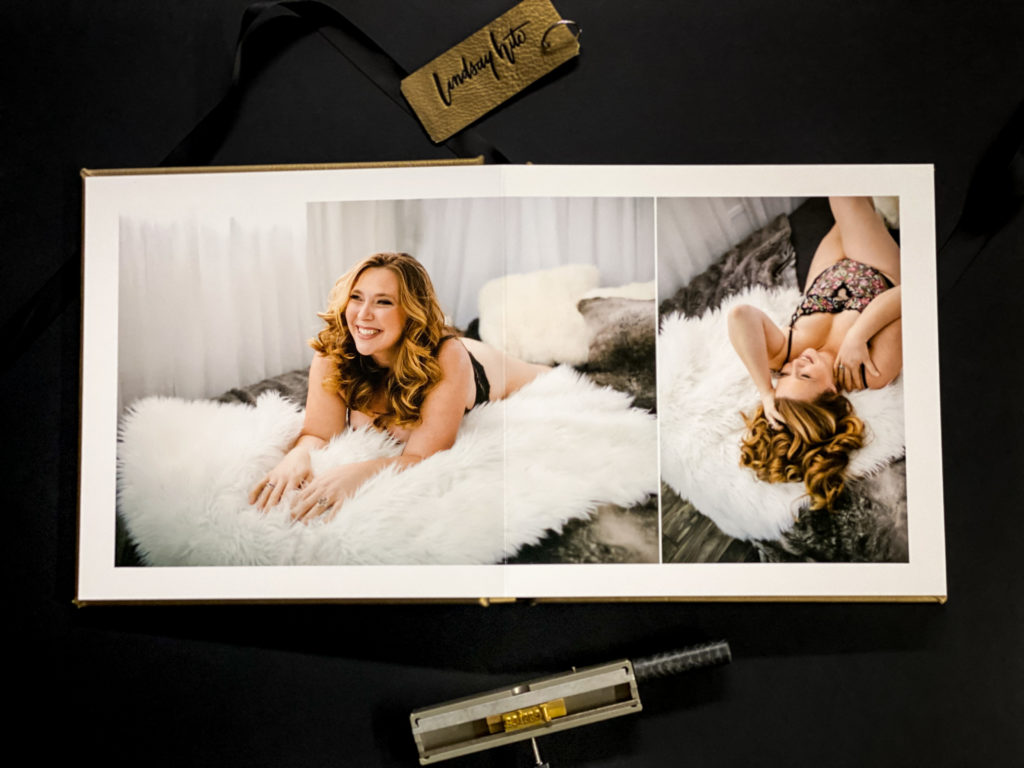 Open album sitting on a black backdrop displaying two portraits of blonde woman in flowery lingerie. Photography by Lindsay Hite of Show Your Spark
