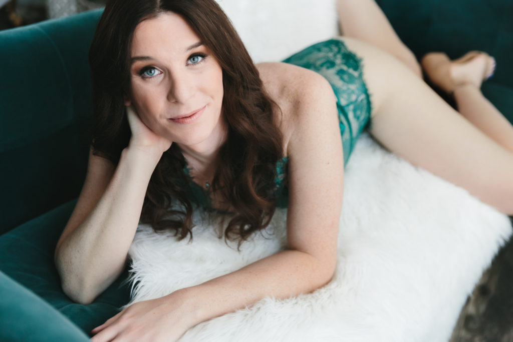 Woman in teal lingerie on white fur-lined bed; photography by Lindsay Hite
