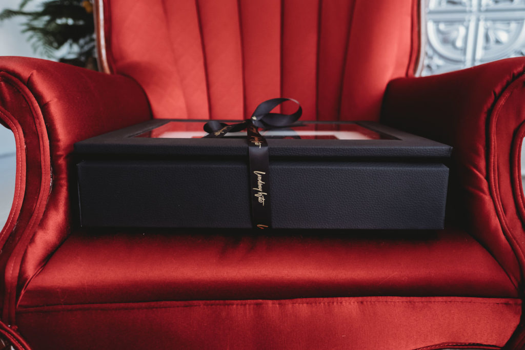 Matted Display Box with ribbon on red chair; photography by Lindsay Hite