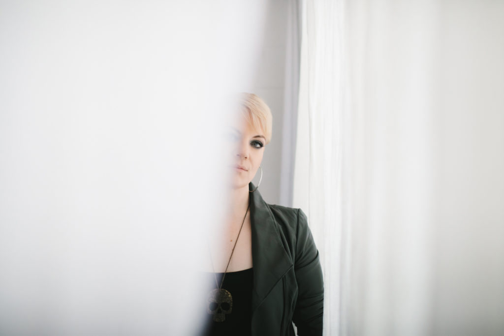 Woman in black behind white curtains.  Photography by Lindsay Hite