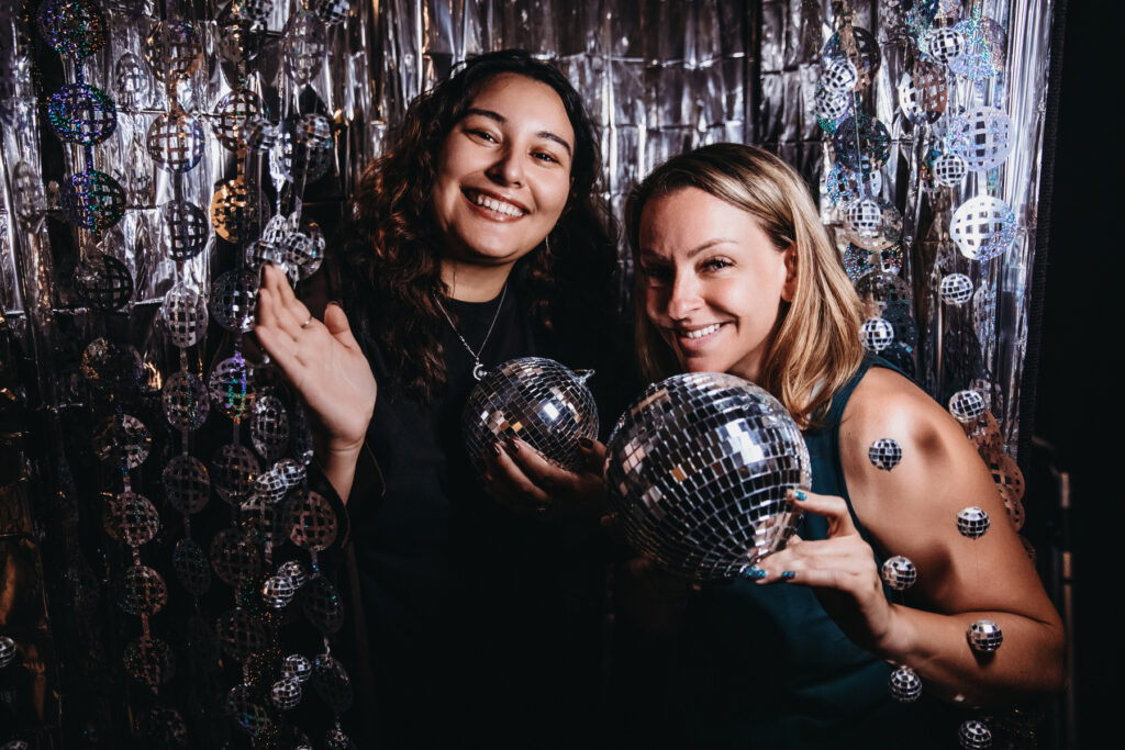 Two women in disco-ball set at Show Your Spark magazine launch.  Photography by Lindsay Hite