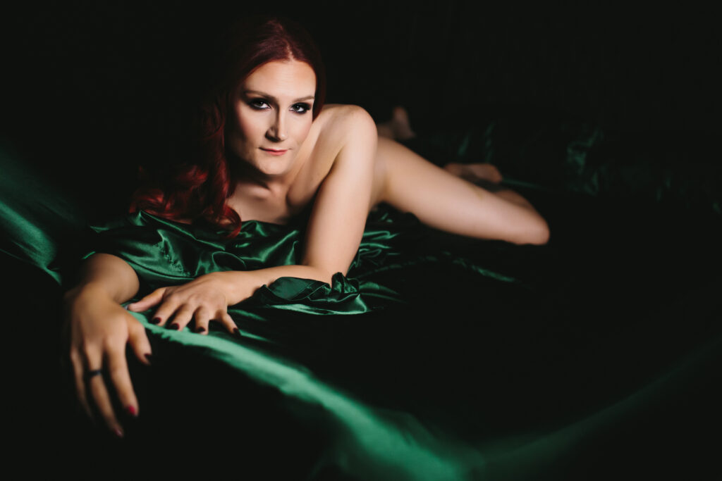 Woman in the nude in green satin sheets.  Photography by Lindsay Hite. 