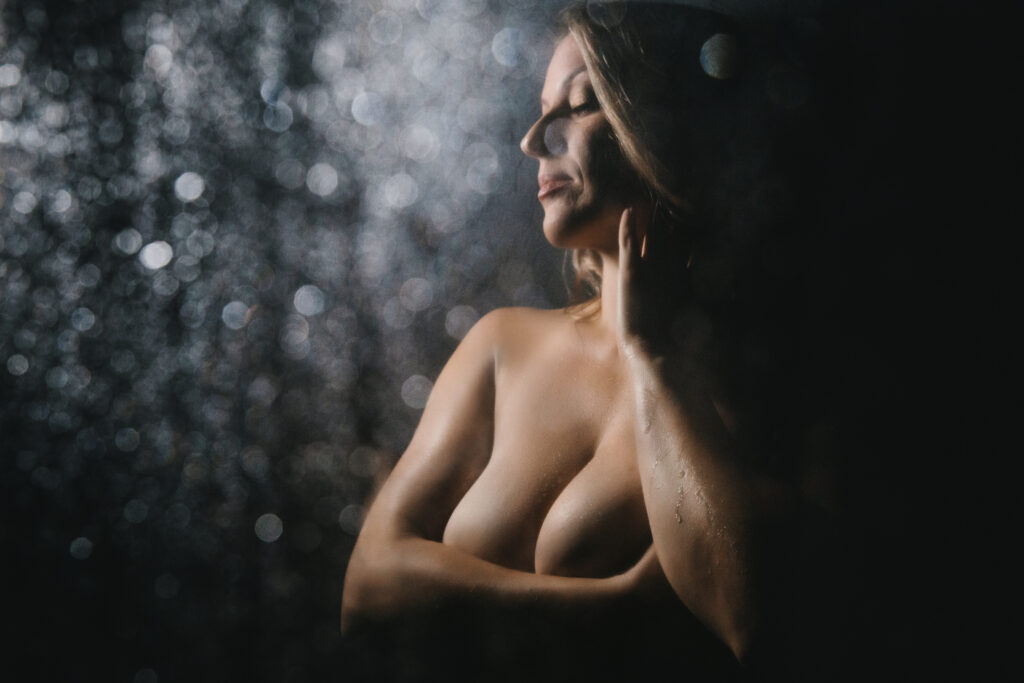 Image of a topless woman in a shower with a black backdrop  Feel your best with Boudoir photography by Lindsay Hite