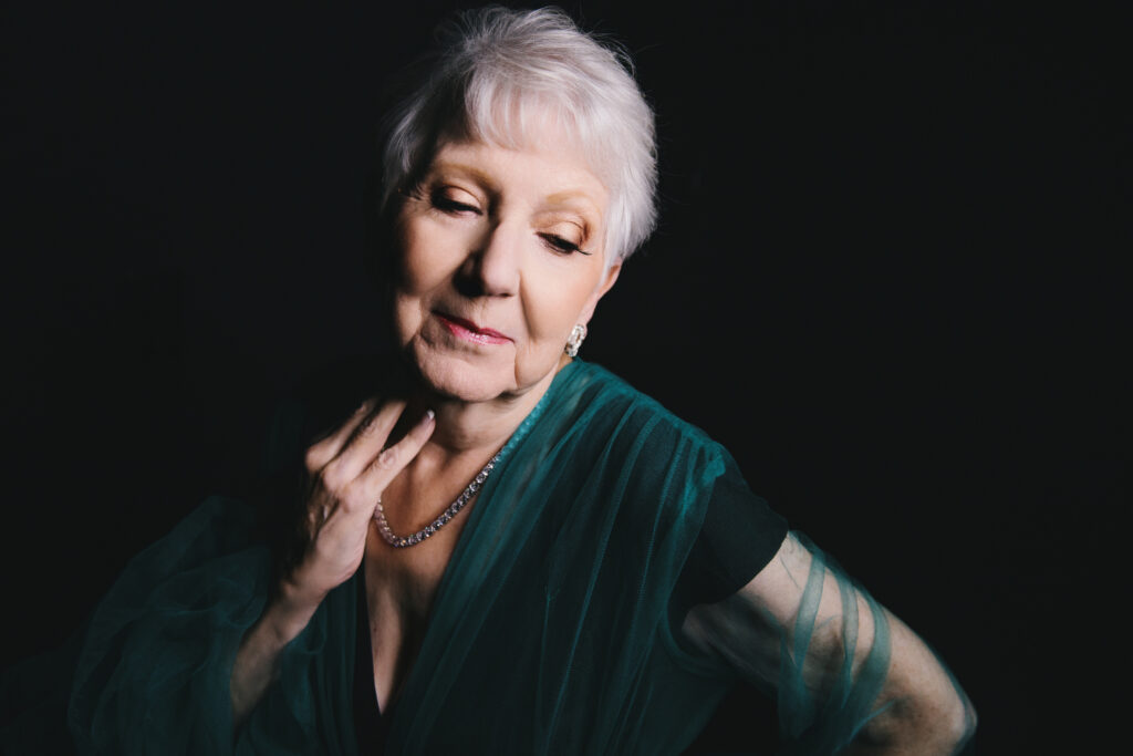 Woman in Green top with black backdrop.  Photography by Lindsay Hite. 