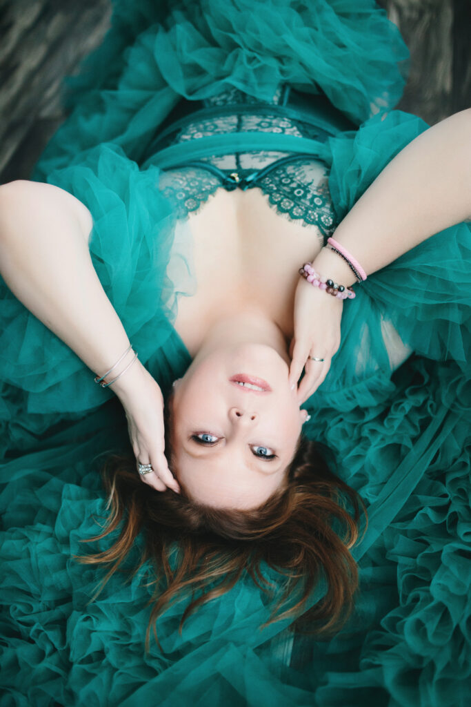 Women in teal lingerie and robe laying on a wood floor, being fierce and unstoppable.  Photography by Lindsay Hite
