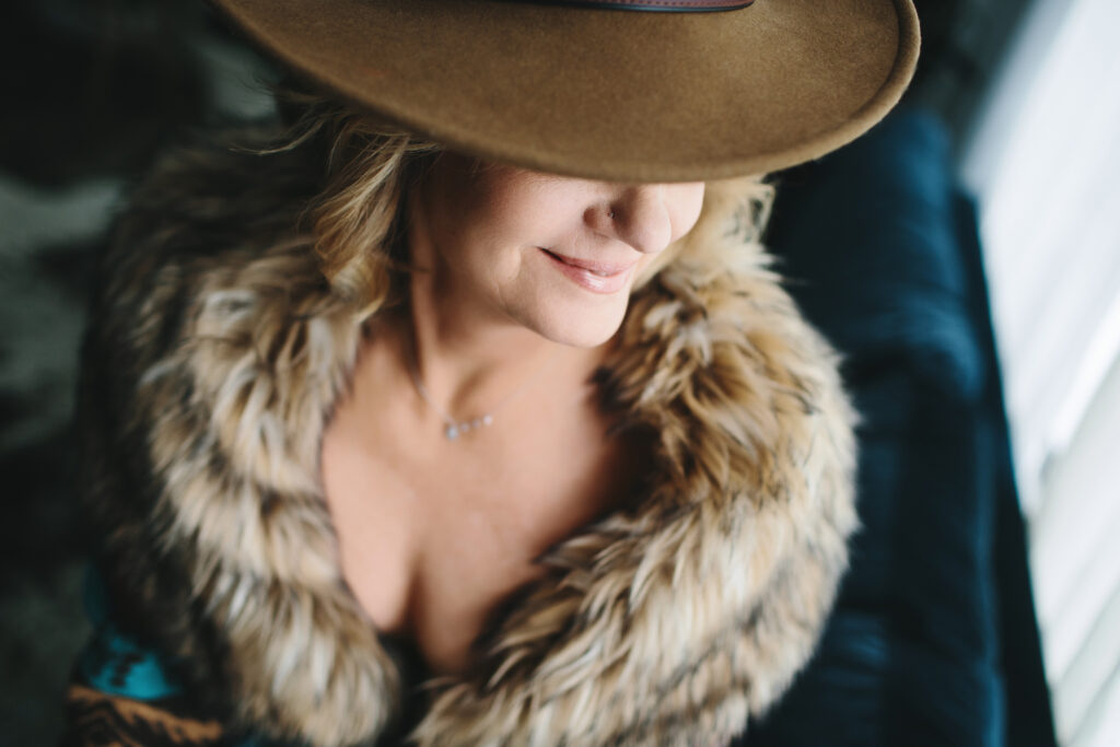 Woman in fur-lined top with a brown-brimmed hat.  Photography by Lindsay Hite