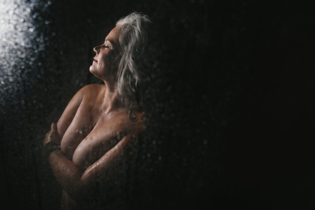 Woman topless in the shower, an artistic nude photograph by Lindsay Hite. 