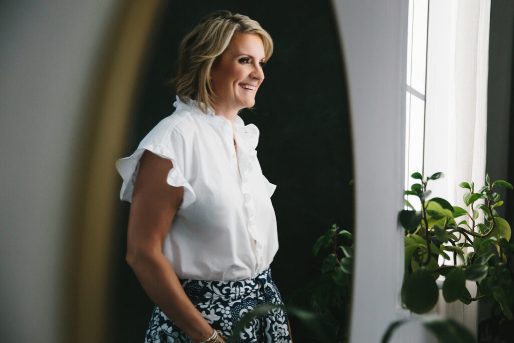 Woman in white blouse and navy and white patterned pants looking forward in life with joy and peace.  Photography by Lindsay Hite