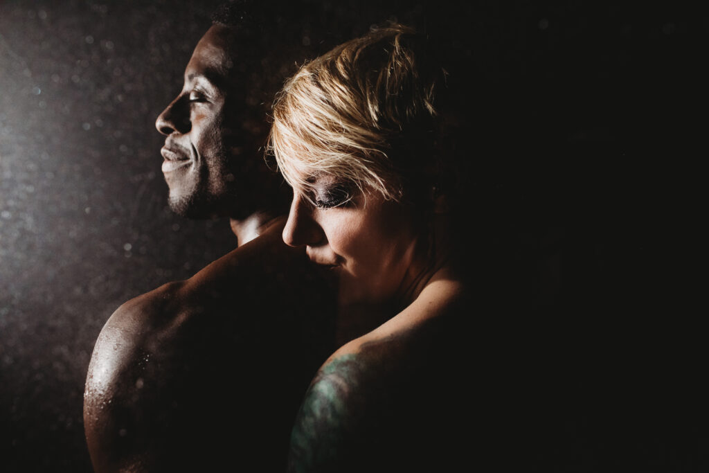 Couple standing close with a black backdrop.  Photography by Lindsay Hite. 