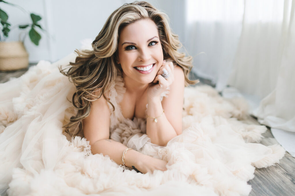 Woman in a blush-colored toile dress looking directly at the camera.  Photography by Lindsay Hite