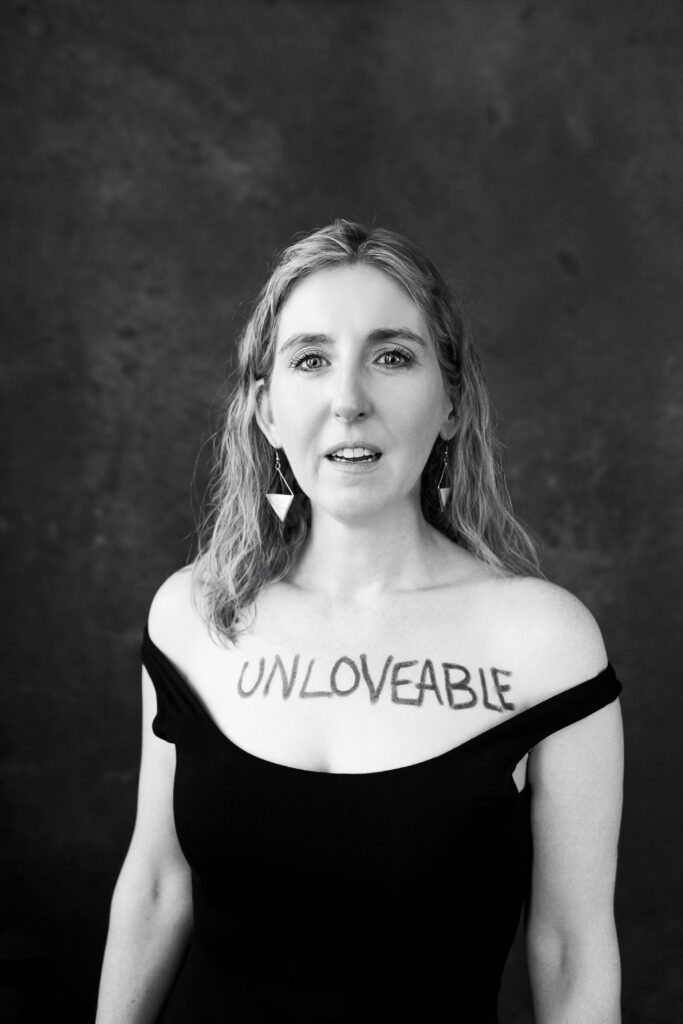 Woman with unloveable written on her chest. 

Photography by Lindsay Hite. 